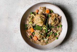 Vegan Chicken and Dumplings in a white bowl on a white marble background