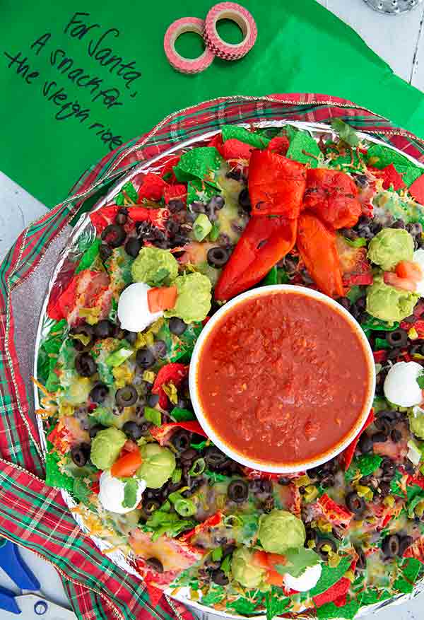 Nachos in the shape of a Christmas wreath with green tissue paper in the background