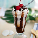 Brownie Milkshake in a tall glass with chocolate syrup and cherries