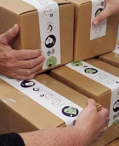 Hands holding multiple boxes to show GIG Cares packages