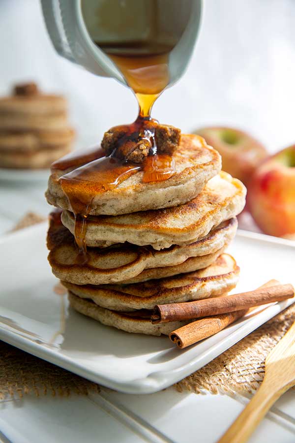 Stack of Granola Pancakes with syrup pouring over top