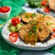 Katsu Curried Eggplant on a bed of white rice with red chilies on top on an emerald green cloth napkin