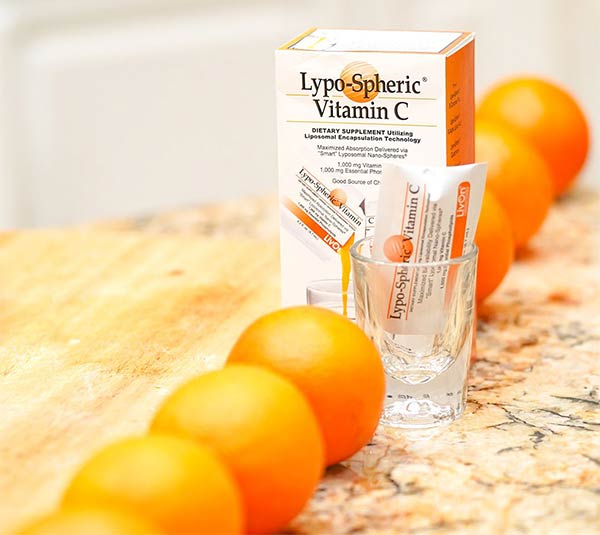 LivOn Labs Lypospheric Vitamin C package lined up with fresh oranges in front and behind it