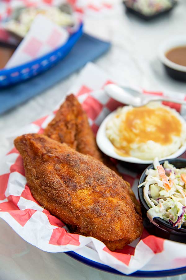 Southern Fry'd Chicken with mashed potatoes and gravy and coleslaw in a basket with red and white paper liner