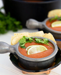 Tomato Tortilla Soup in a silver bowl topped with cilantro and lime