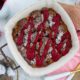 Overhead view of Triple Berry Bread Pudding in a white casserole dish with pink feminine placesetting
