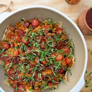 Overhead view of Plant-Based Tortilla & Jackfruit BBQ Casserole in a white bowl on light wood background