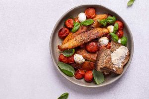 Caprese Chicken in a gray bowl on a white background