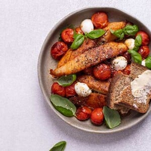 Caprese Chicken in a gray bowl on a white background