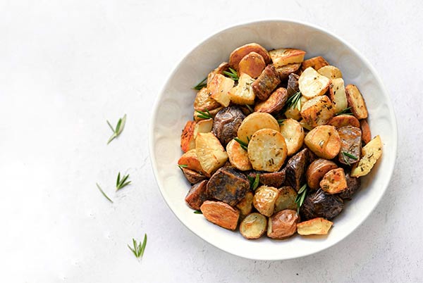 Rosemary Roasted Potatoes in a white bowl on a white background