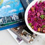 caraway spiced red cabbage in a white bowl with German postcards underneath