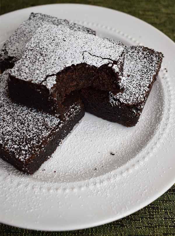 Superfree Bakehouse Brownies on a white plate with powdered sugar on top