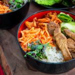 Closeup of Easy Beef Bulgogi Bowls in black and red bowls on a dark wooden serving board