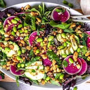 Overhead view of Seasonal Salad with Baked Lemon Tofu Bits on a white oval platter
