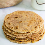 Stack of Cassava Flour Tortillas on a white marble table with jar of cassava flour in the background