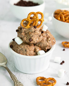 Not-So-Rocky Road Ice Cream in a white ramekin topped with pretzels with a bowl of pretzels and chocolate chips in the background on a white marble counter