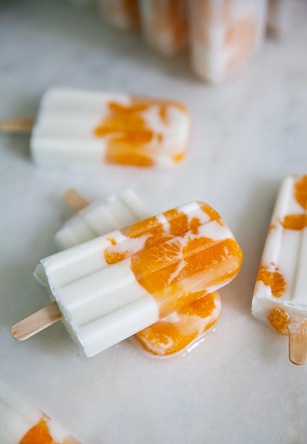 White and orange Sunshine Popsicles on a white counter