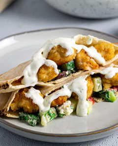 Chicken Tender Pitas on a white plate with tzatziki sauce drizzled on top