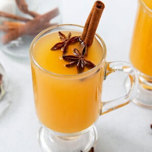 Cough-Soothing Kinderpunsch in two clear glass mugs with star anise and cinnamon sticks inside