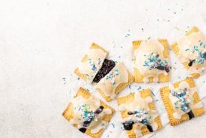 An overhead view of Pop Tarts with one cut in half with the inside filling spilling out.