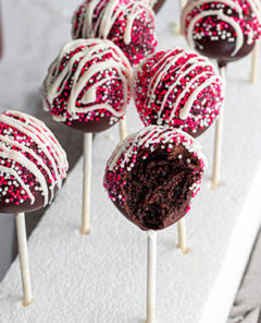 an overhead view of two rows of decorated cake pops with a bit taken out of one.