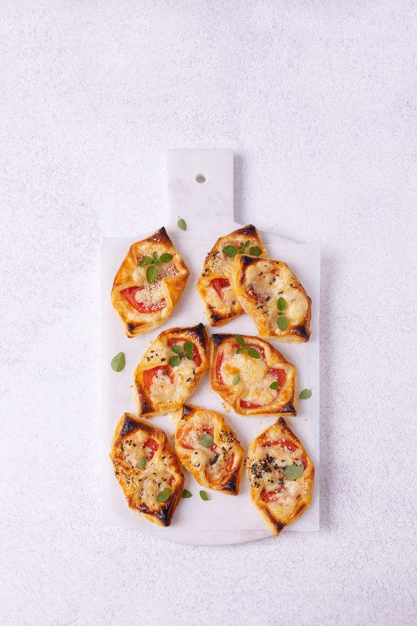 Cheese and tomato pastries on a serving tray.