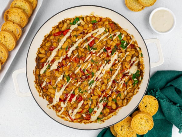 he Warm Cannellini Bean dip on a white platter with bread next to it.